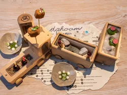 Gourmet-Vorspeise in hölzernem Spielzeugzug mit kleinen Schälchen und kreativer Präsentation serviert