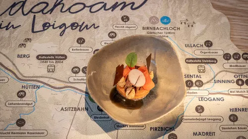 Gourmet appetizer in ceramic bowl displayed on a Leogang region map