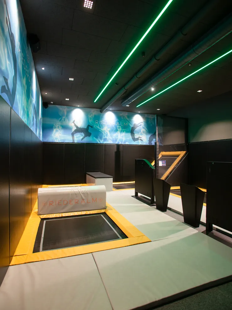 Indoor trampoline park at Riederalm with padded floors and neon lighting