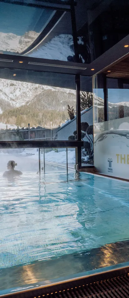 Thermal-Innenpool mit Bergblick im luxuriösen Alpen-Spa-Resort im Winter