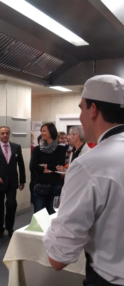 Chef talking to guests during a kitchen tour or cooking event