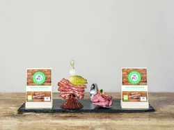 Organic cold cuts of Loigomer Polish sausage and Asitz mountain ham served decoratively on slate platter