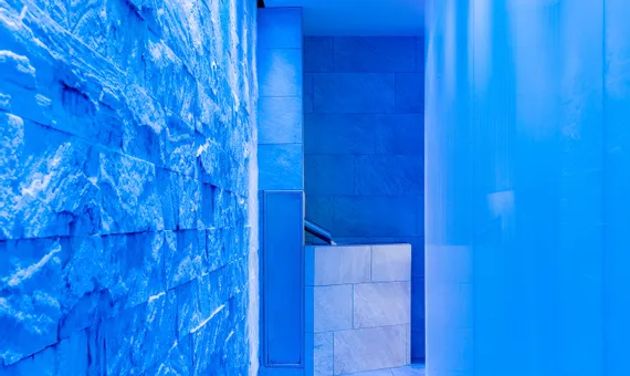 Moderner Spa-Flur mit blauer Ambientebeleuchtung und Steinwänden