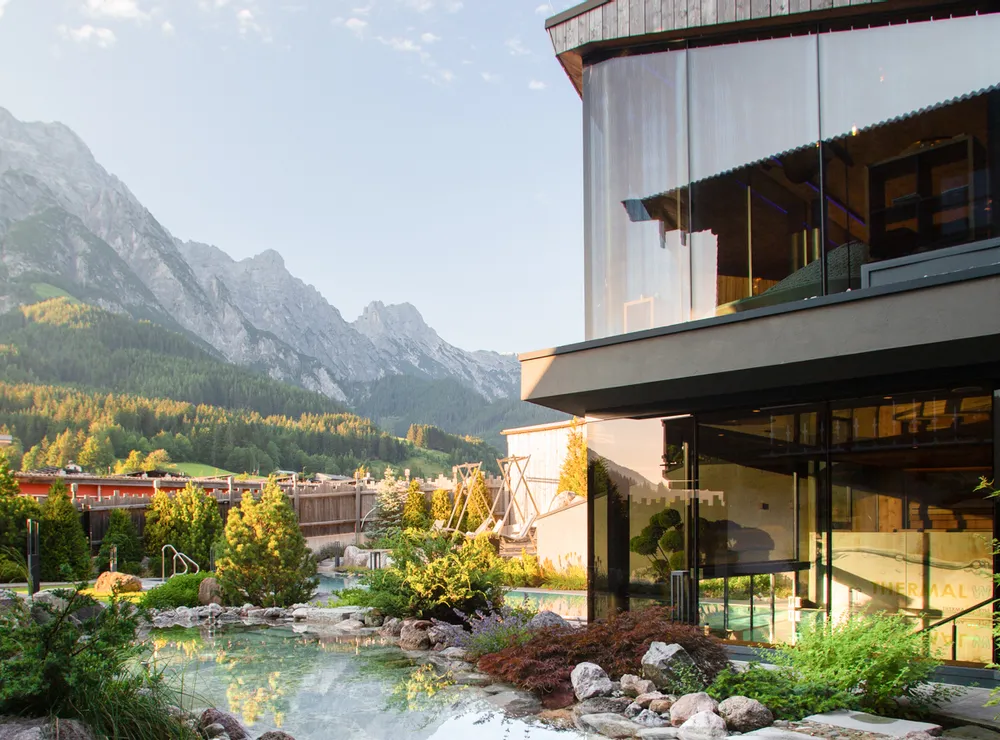 Modernes Spa-Resort mit Kneippteich und Bergblick in alpiner Landschaft