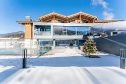 Modern hotel with glass facade and outdoor pool in a snowy winter holiday destination