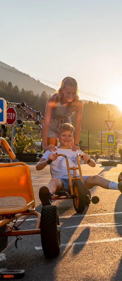 Children playing with pedal go-karts on a sunny day in Salzburg outdoor area
