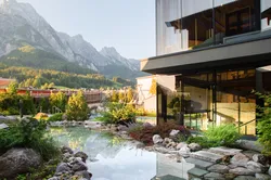 Modernes Spa-Resort mit Kneippteich und Bergblick in alpiner Landschaft