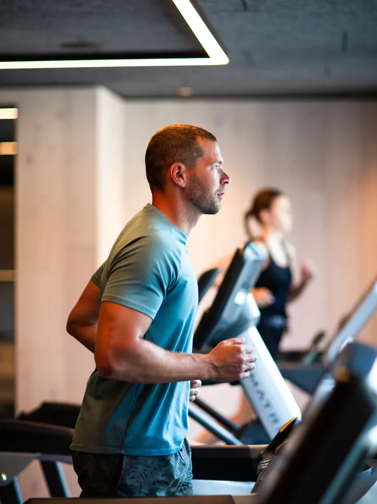 Man running on a treadmill at a modern gym