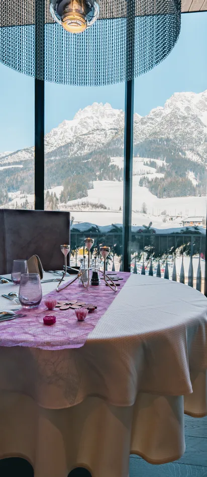Set restaurant table with panoramic view of snowy Alpine mountains