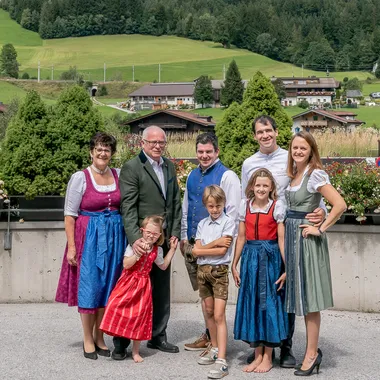 Familie in traditioneller österreichischer Tracht vor Alpenkulisse
