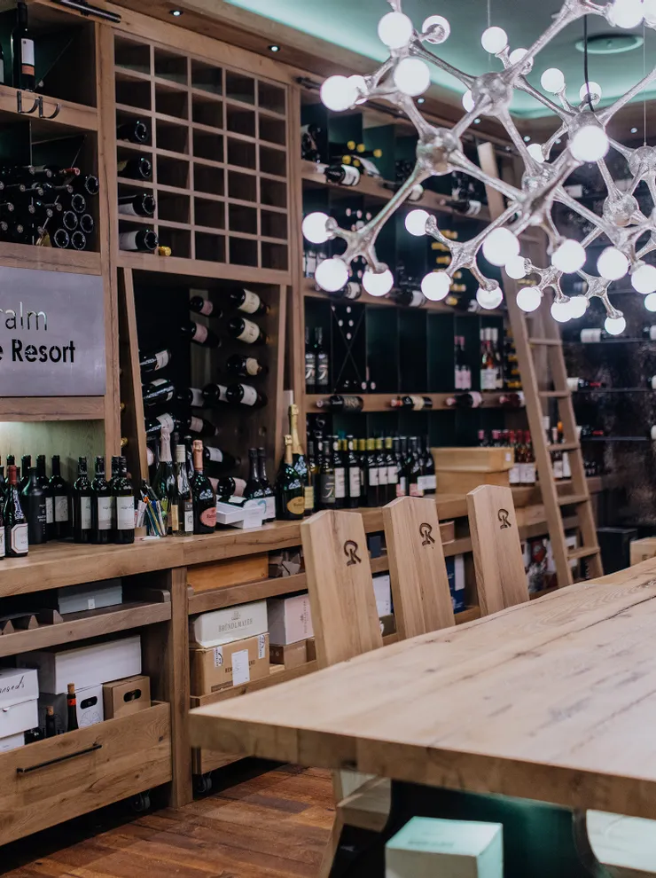 Modern wine cellar at Riederalm Good Life Resort with wooden decor and illuminated chandelier