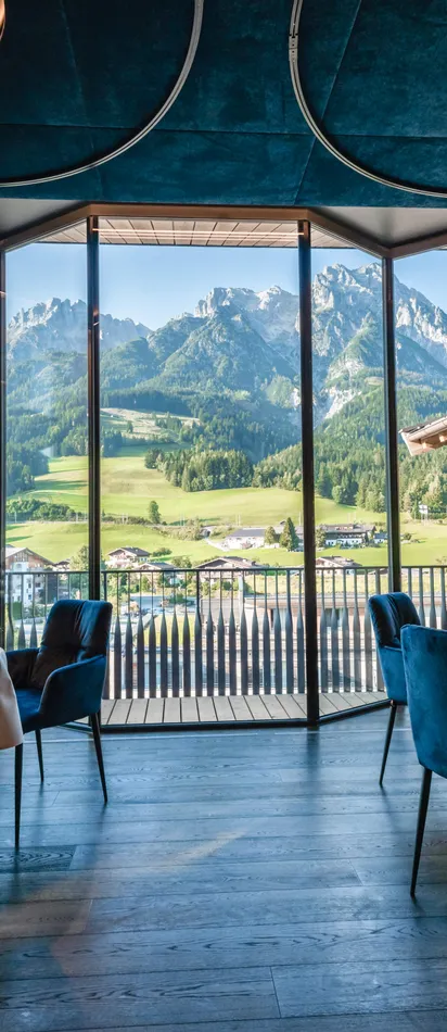 Elegant restaurant with mountain view through large window in alpine setting