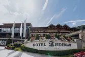 Außenansicht des Hotels Riederalm mit Blumenschmuck und Beschilderung im Resort Leogang