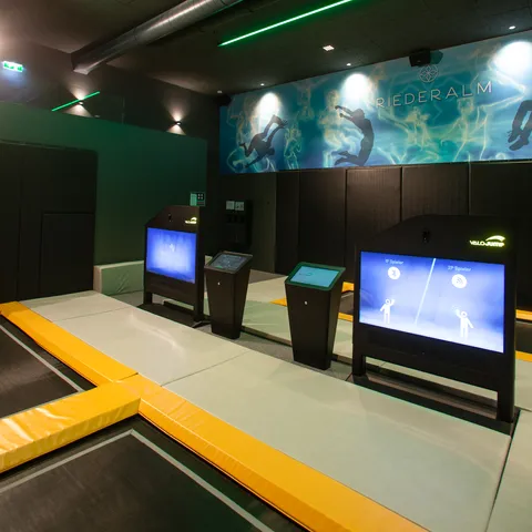 Indoor trampoline park with interactive ValoJump screens and padded jumping zones