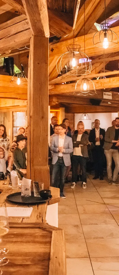 People attending a wine tasting event in a rustic wooden venue