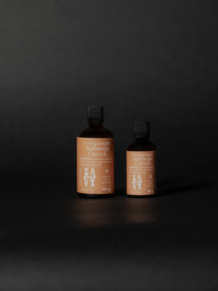Two bottles of Leoganger Saiblings Garum fish sauce on black background