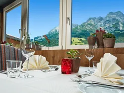 Eleganter Restauranttisch mit Bergblick durch große Fenster