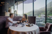 Paar genießt romantisches Abendessen mit Wein im Restaurant mit Bergblick