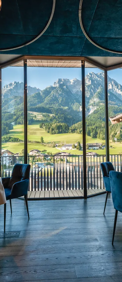 Modern restaurant with panoramic window view of alpine meadows and mountain landscape