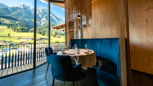 Elegant mountain view restaurant with round table and blue velvet seating