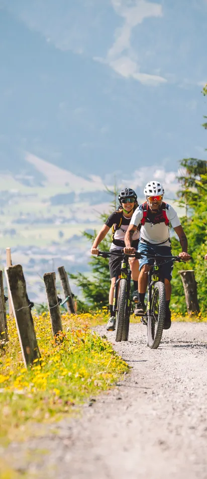 Gruppe von Radfahrern beim Mountainbiken auf einem malerischen Alpenpfad im Sommer