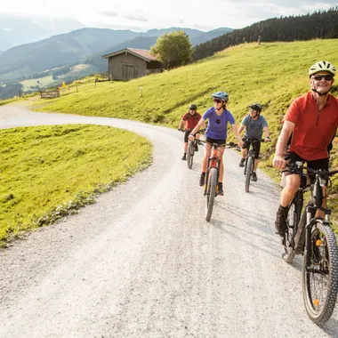 Gruppe von Radfahrern auf Mountainbikes auf einem Schotterweg durch eine idyllische Landschaft