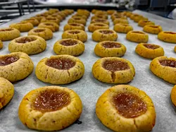 Frisch gebackene Engelsaugen mit Marmeladenfüllung auf einem Backblech mit Backpapier