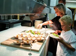 Frau und Junge holen Vorspeisen und Salat an einem Buffet im Restaurant